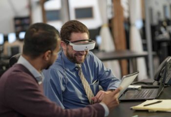 A man using eSight glasses to read a document. 