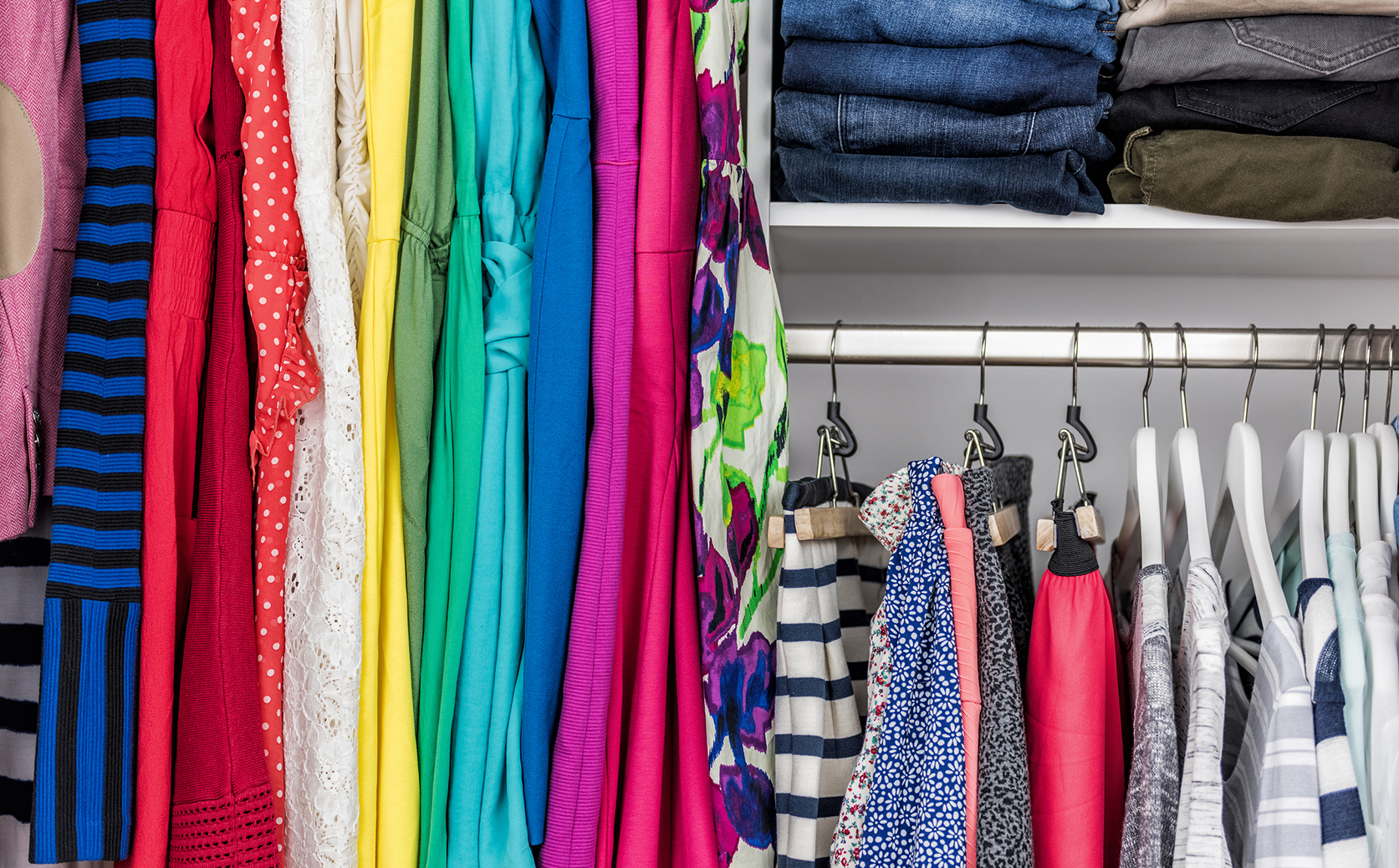 Colorful clothing organized in a closet.