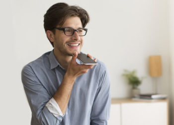 Image of man talking into smartphone on speaker.