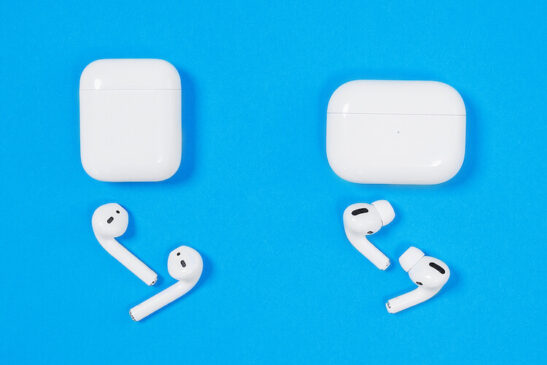 Apple AirPods and AirPods Pro side by side on blue background.
