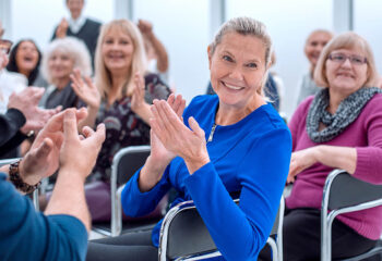 Image shows group of AMD patients applauding.
