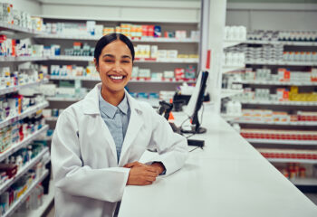 Image shows helpful, smiling pharmacist at work.