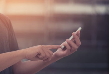 Image shows hands tapping VoiceOver gestures on iPhone.