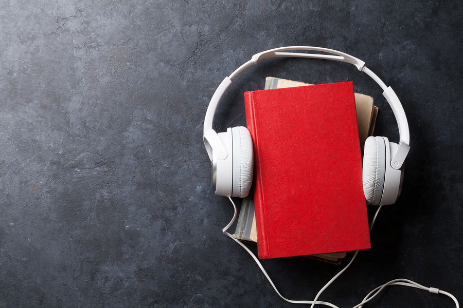 White headphones around red book on table