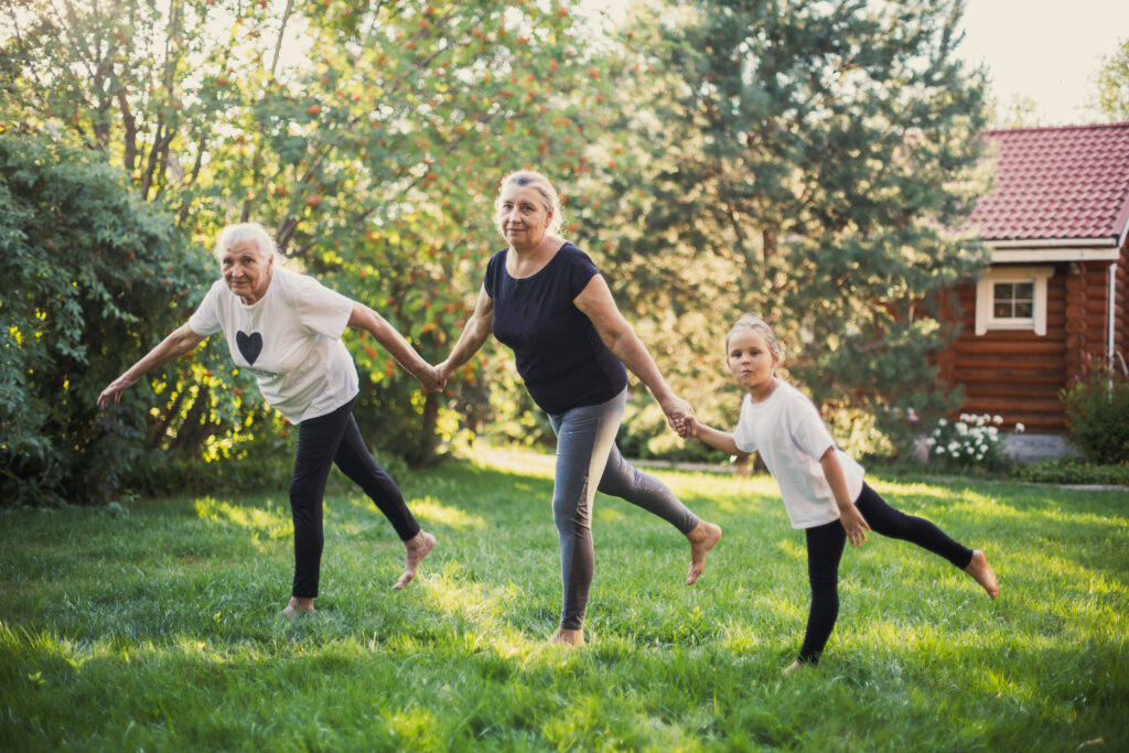 Grandmother, daughter and granddaughter practicing balance outdoors