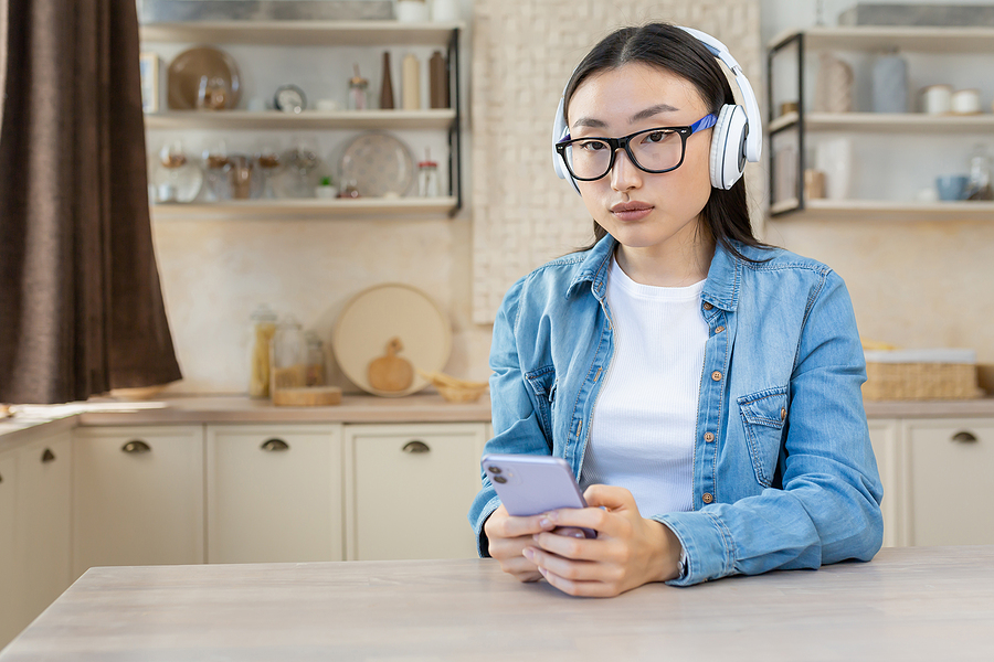 Young woman with headphones, deeply focused in audiobook