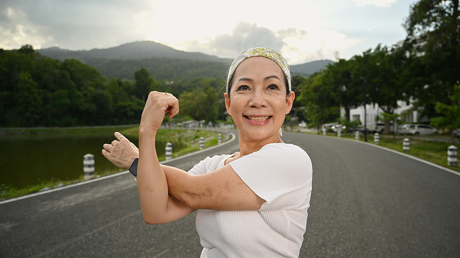 Smiling mature woman stretching after workout