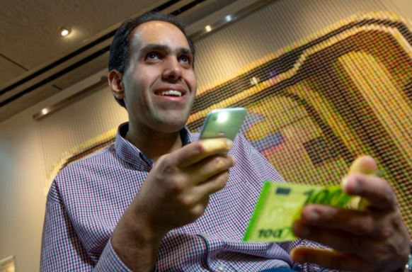 Microsoft engineer and Seeing AI developer, Saqib Shaikh, smiles broadly as he uses the app.  Image credit: Microsoft 