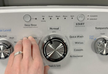 Hand touching tactile stickers on GE washer